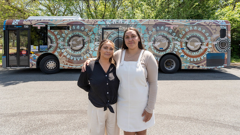 Ngunnawal artists Lynnice Church and Leilani Keen-Church standing in front of the TC bus with the new RAP wrap