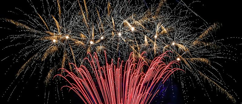 Red and orange fireworks exploding against a dark sky.