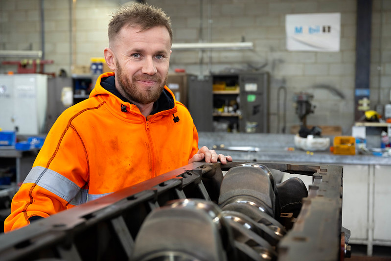Person working on vehicle components in a Transport Canberra fleet workshop.